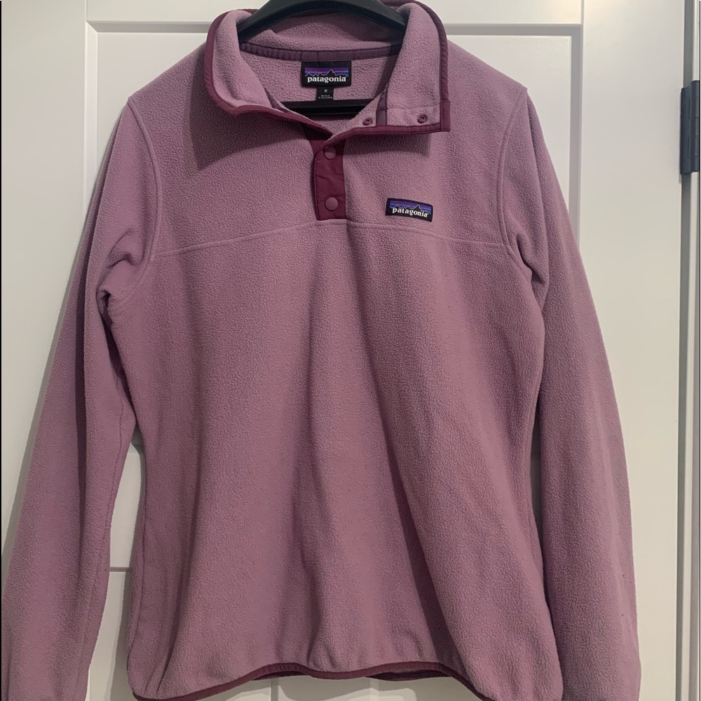 The brand of this sweater is Patagonia, it’s a size medium, and is light purple